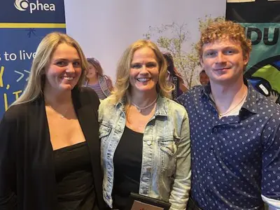 Three people posing for a photo standing side by side. 