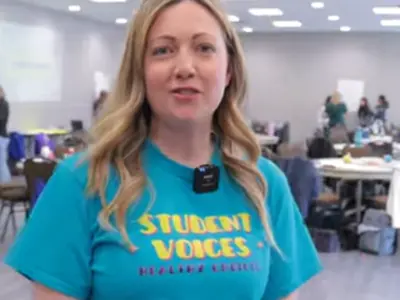 close up of a woman wearing a teal t-shirt. 
