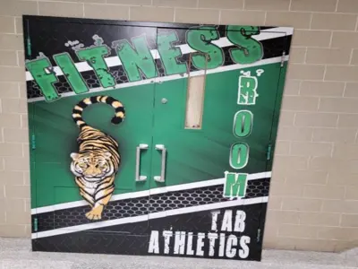 Doors shown with green mural on them. Green background labelled "Fitness room, TAB Athletics". There is an orange and white tiger shown in a prowl posture.