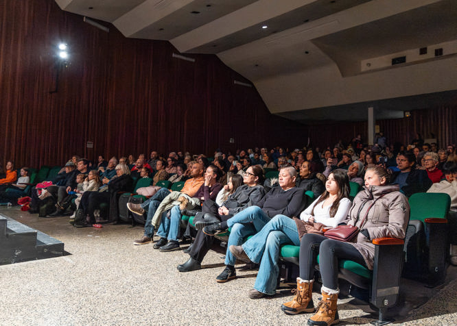 parents sitting in a crowd in a school auditorium